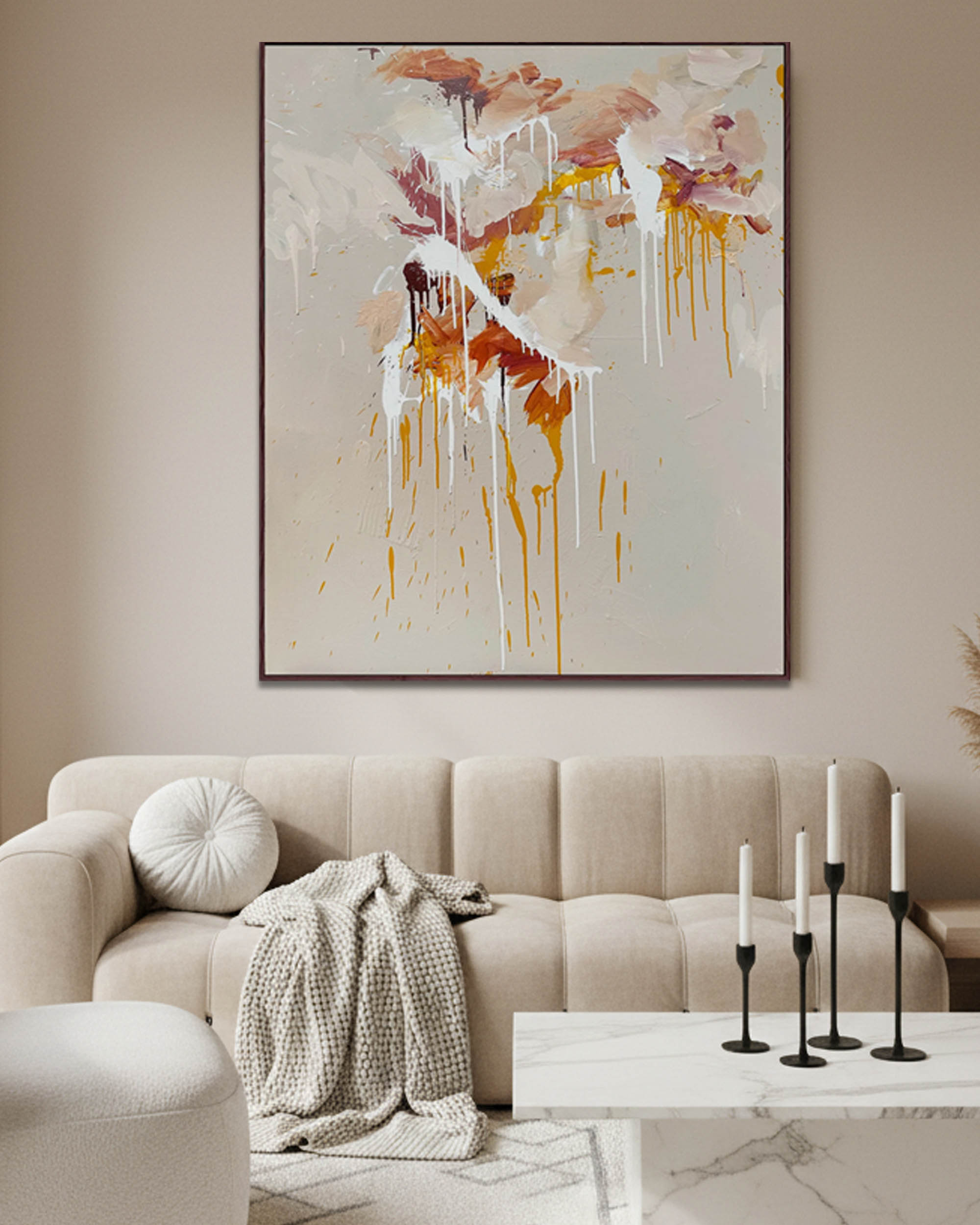 Living room with a beige sofa, abstract painting, and decorative candles.