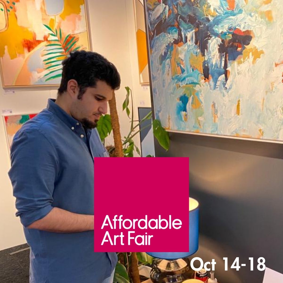 A man in a blue button-down shirt stands indoors near colorful abstract wall art and a plant, with a large pink overlay reading 'Affordable Art Fair' and text 'Oct 14-18' in the lower right.