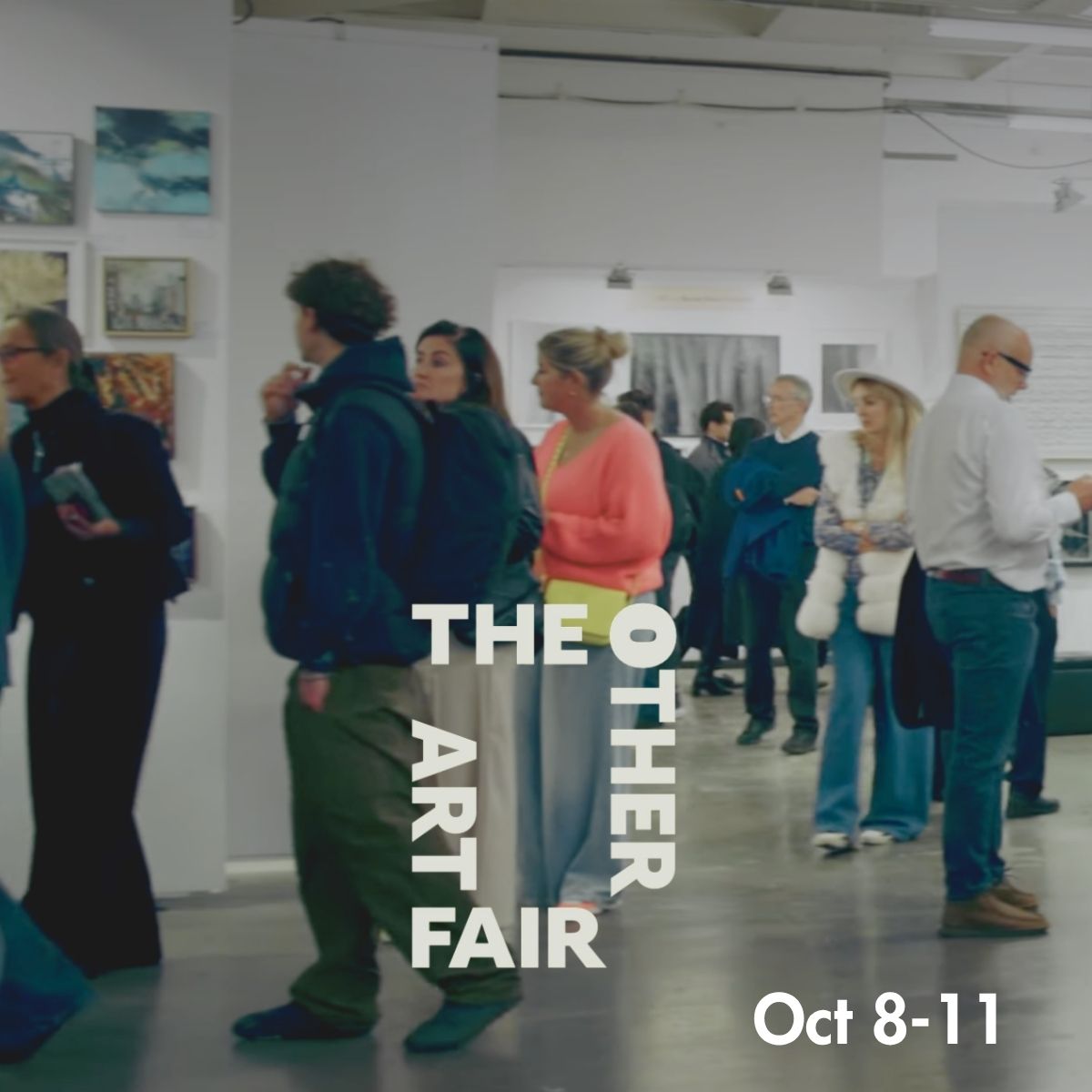 A group of people walking and talking inside an art gallery or fair space, with framed artwork visible on the walls. Large overlaid text reads 'THE OTHER ART FAIR' and 'Oct 8-11'.