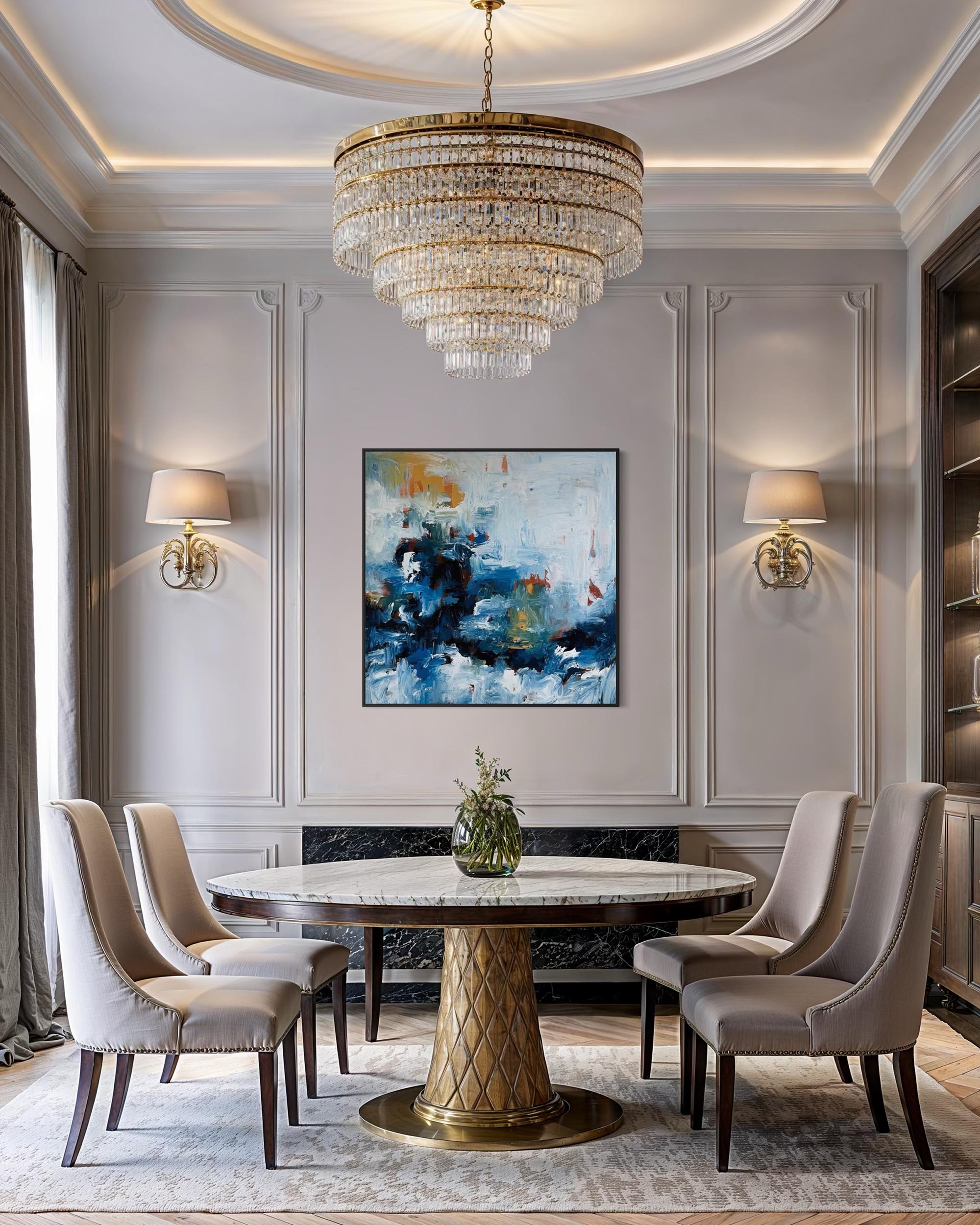 Elegant dining room with a round marble table, gold chandelier, and abstract art on the wall.